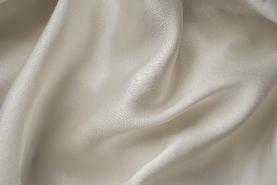 Abito lungo in seta color avorio con drappeggio asimmetrico