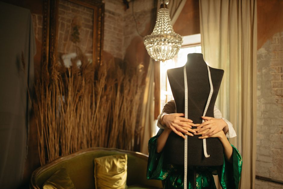 Atelier di alta moda con manichini e tessuti pregiati, luce soffusa
